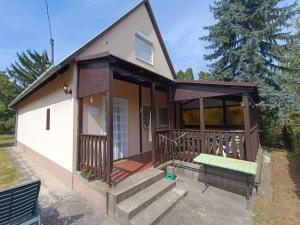a small house with a porch and a bench at Hattyú Vendégház in Gárdony