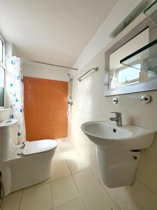 a white bathroom with a sink and a toilet at Ananya Apartments Phase 1 in Kathmandu