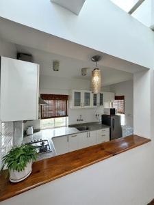 a kitchen with white cabinets and a wooden counter top at Ananya Apartments Phase 1 in Kathmandu