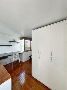 a room with white cabinets and a table and a chair at Ananya Apartments Phase 1 in Kathmandu