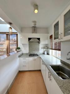 a kitchen with white cabinets and a sink at Ananya Apartments Phase 1 in Kathmandu