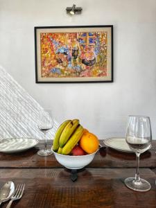 a bowl of fruit on a table with two wine glasses at Ananya Apartments Phase 1 in Kathmandu