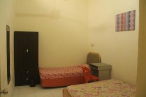 a small room with two beds and a table and a bed sidx sidx at kluang homestay villa 1 in Kluang +8 photos