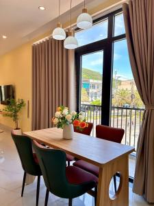 Tay PhuongにあるVictory Quy Nhon homestayのダイニングテーブルと椅子、そして大きな窓