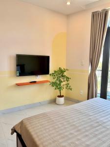 Tay PhuongにあるVictory Quy Nhon homestayのベッドと壁にテレビが掛かった寝室 +50枚の写真