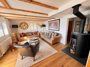 a living room with a wood stove and a couch at Chalet AlpinLux in Beatenberg in Beatenberg