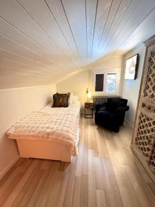 a bedroom with a bed and a chair in a room at Chalet AlpinLux in Beatenberg in Beatenberg +97 photos