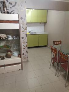 Una cocina con gabinetes verdes y una mesa y sillas. en Вилла Яна, en Sveti Vlas