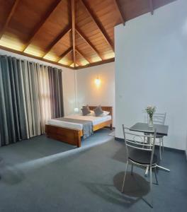 a bedroom with a bed and a table and a chair at The kandy downtown in Katugastota