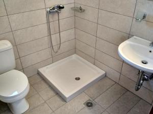 a bathroom with a shower and a toilet and a sink at Porto Heli Apartments in Palekastron