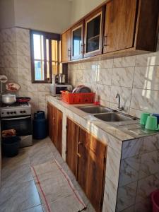 a kitchen with wooden cabinets and a sink at Odoux in Adékplovi