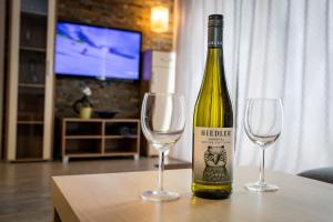 butelka wina i dwa kieliszki do wina na stole w obiekcie Apartment-Alpenfantasie w mieście Zell am See