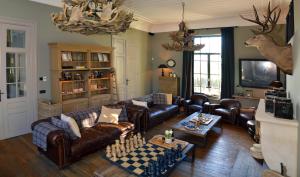 a living room with leather couches and a chess board at Chateau Beausaint in La-Roche-en-Ardenne