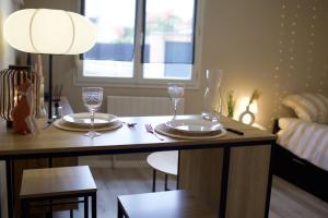 une table à manger avec deux assiettes et des verres dessus dans l'établissement Studio douillet proche gare, à Clermont-Ferrand 11 autres photos