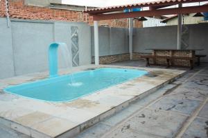 a swimming pool with a water fountain in a patio at Casa de praia DM in Luis Correia