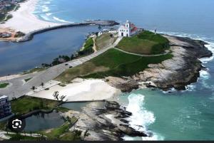 a lighthouse on an island in the ocean at Casa aconchegante em Saquarema in Saquarema
