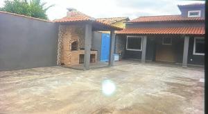 a patio in front of a house with a blue door at Casa aconchegante em Saquarema in Saquarema