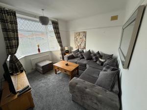 a living room with a couch and a table at Victoria Beach Cottage in Prestatyn