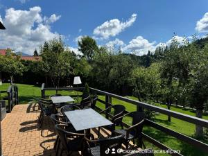a group of tables and chairs on a patio at Cazare Colibița Casa Lipan cu jacuzzi, foișor și loc de joacă in Colibiţa +138 photos