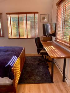 a bedroom with a bed and a desk with a computer at Little Cabin in Middlepoint in Halfmoon Bay