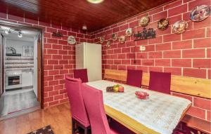 ein Esszimmer mit einem Tisch und einer Ziegelwand in der Unterkunft Nice Apartment In Ledenice With Wifi in Ledenice