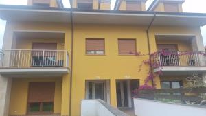a yellow building with two balconies on it at Aldea Bricia 20 BC in Posada de Llanes