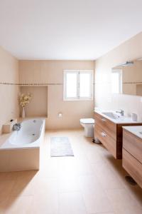 a bathroom with two sinks and a tub and a toilet at Villa Sol Nudist Place in Charco del Palo