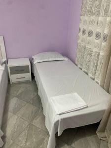 ポグラデツにあるGenti Guesthouseのベッドとナイトスタンドのある小さな寝室