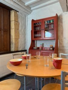 a kitchen with a wooden table with bowls on it at Gîte Mac Arthur in Bulson