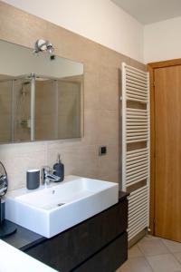 a bathroom with a white sink and a mirror at Riva Central Apartment - Free Parking in Riva del Garda