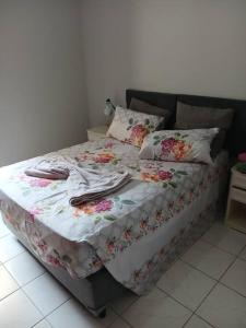 a bed with a blanket and pillows on it at Apartamento Praia das Pitangueiras - Condomínio Golden Tower in Guarujá