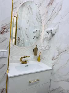 a white bathroom with a sink and a mirror at Golden Apartment in Santander +10 photos