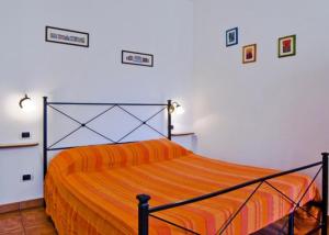 a bedroom with a bed with an orange bedspread at B&B Acquedotti Antichi in Rome