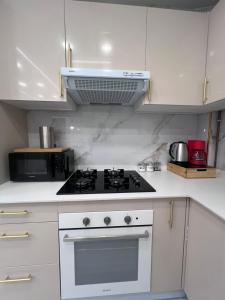 a white kitchen with a stove and a microwave at Golden Apartment in Santander