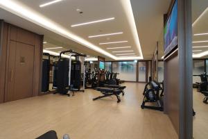 a gym with tread machines and a flat screen tv at Address Residence Bahrain in Rayyā