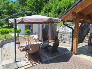 a group of chairs under an umbrella on a patio at Chalet Letnik in Žiri
