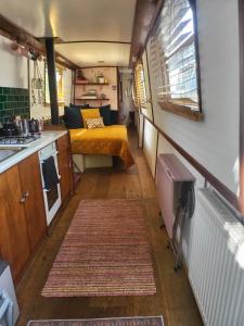 a small room with a bed and a kitchen at Lovely Canal Boat in Little Venice for Family & Friends in London