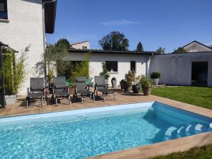 a swimming pool with chairs and a house at Le Doubs repère in Montferrand-le-Château