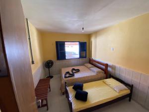 a small room with two beds and a television at Casa de praia DM in Luis Correia