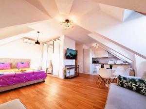 a living room with a purple bed and a kitchen at Bucharest Central E Apartment in Bucharest