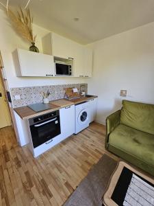 a living room with a couch and a kitchen at "L'escapade Havraise" Studio Parking gratuit Coeur de Ville in Le Havre +7 photos