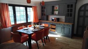 a kitchen with a table with red chairs and a kitchen withilitation at St Edmunds Brewery in Downham Market