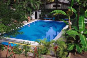 a large blue swimming pool in a yard with trees at Rincon del mar in La Libertad