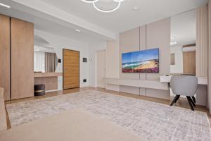 a living room with a television on a wall at Uno Deluxe Home Brasov in Braşov +22 photos