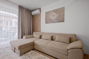 a living room with a couch and a window at Uno Deluxe Home Brasov in Braşov