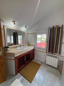 a bathroom with a sink and a mirror at Casa rural chimenea y barbacoa in Escorial