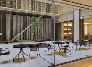 a lobby with tables and chairs and a potted plant at Richmond Hotel Tokyo Shiba in Tokyo