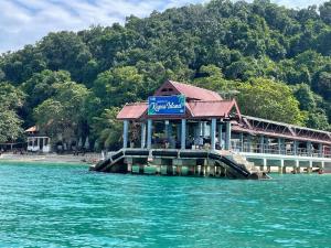 een restaurant op een pier op een waterlichaam bij Eyka Studio Roomstay in Marang