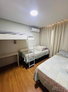 1 Schlafzimmer mit 2 Etagenbetten und einer Leiter in der Unterkunft Home Club em Barra Velha in Barra Velha