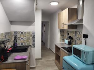 a kitchen with a microwave on top of a counter at Apartamento La Avenida in Lanjarón